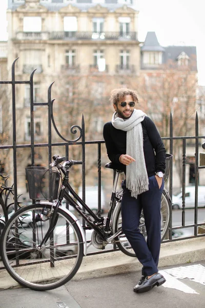Modelo masculino de moda en gafas de sol redondas de pie cerca de la bicicleta . — Foto de Stock
