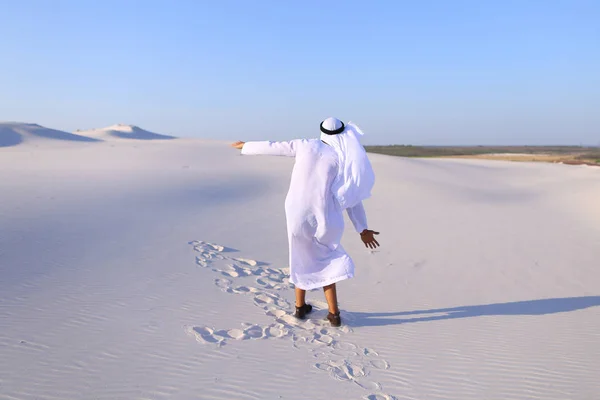 Hombre árabe feliz camina en medio del desierto blanco y disfruta de la vida o —  Fotos de Stock