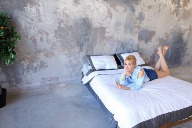 Büyüleyici kadın elinde fotoğraf makinesi telefon ile poz ve yatan