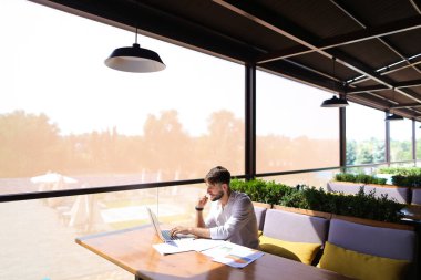 Amerikalı yatırımcı laptop ve diyagram belgelerle çalışma