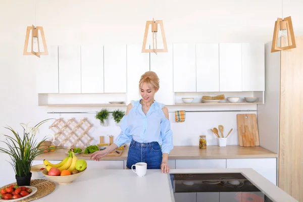 Pretty girl walks into kitchen and stretches, enjoying morning c