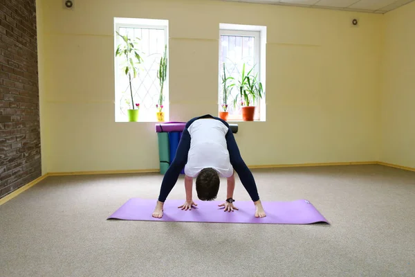 Vacker ung kvinna med mörka haired utför yogaövningar. — Stockfoto