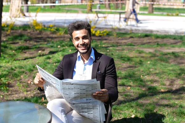 Αραβική μόλις αγόρασα νέα καθημερινή εφημερίδα και ανάγνωση στο πάρκο. — Φωτογραφία Αρχείου