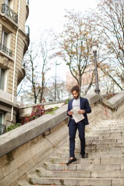 Gazete adımlarla yürürken yakışıklı mix kan adam.