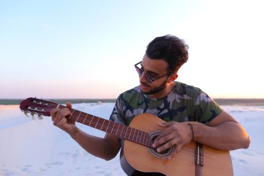Arap yakışıklı genç gitar mi Hill'de oturan, ayarlar