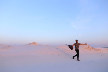 Arap adam çöl güzelliği ile ilham gider ve gitar çi çalış