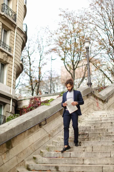 Gazete adımlarla yürürken yakışıklı mix kan adam.