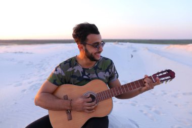Sevimli genç erkek Arap ses gitar, Hill'de oturan sahiptir