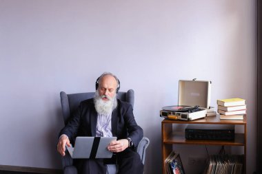 Kıdemli bilgisayarda çalışır ve kulaklık müzik hoşlanır