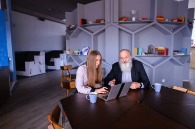 Yaşlı adam meslektaşım başarılı ile dizüstü bilgisayar kullanarak iş kadını