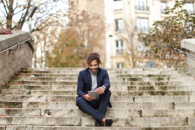 Yakışıklı yarım Nijeryalı adam adımları tablete tarafından kızla sohbet