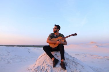 Çekici Arap adam gitar, Hill'de oturan şarkı söylüyor