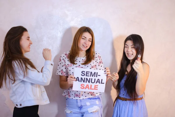 Drie stijlvolle vriendinnen poseren met teken en roepen voor sh — Stockfoto