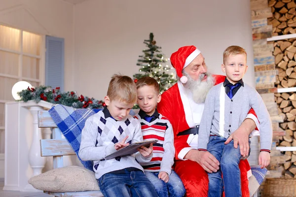 Niños pequeños con Santa Claus jugando con la tableta . — Foto de Stock