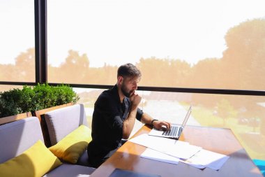 Miktar arazi kafeterya masada kağıtları ve dizüstü bilgisayar ile çalışma.