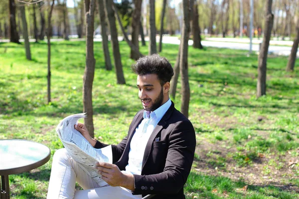 Successful businessman reading newspaper at lunch.