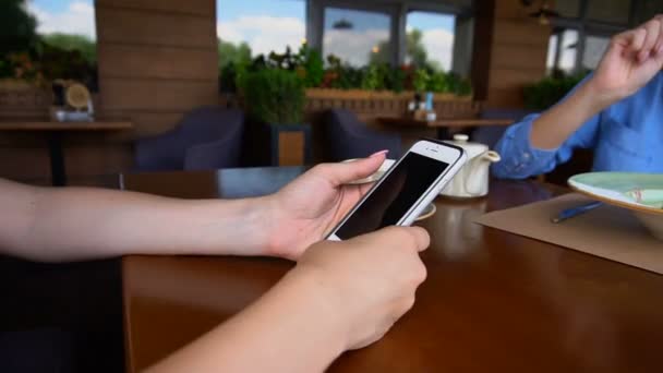 Close up hands with long nails browsing by smartphone at cafe during lunch. — Stock Video