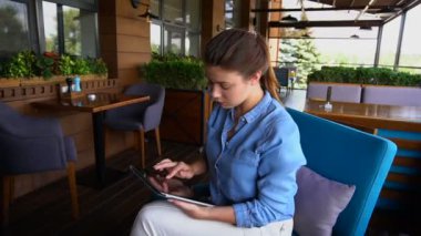 Güzel kız ağır çekimde restoranda tablet ile çalışma.