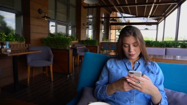 Belle adolescente profitant des réseaux sociaux par smartphone au restaurant au ralenti . — Video