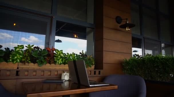 Närbild av laptop och svart anteckningsbok på restaurang bordet. — Stockvideo