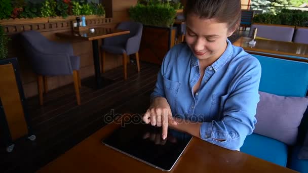 Wesoła dziewczyna praca z tabletem w restauracja stół. — Wideo stockowe