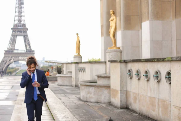 Mulato menino falando com a namorada por telefone perto Eiffel Towe . — Fotografia de Stock