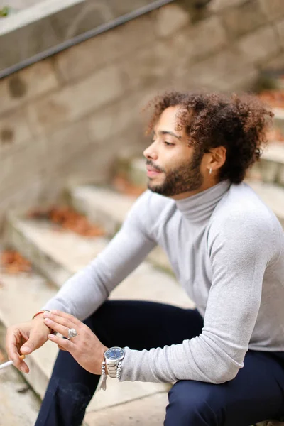 Kleiner halb nigerianischer Junge lächelt auf Stufen und schaut zur Seite. — Stockfoto