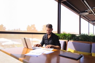 Başarılı foreman kafede dizüstü ve belgeleri kullanma.