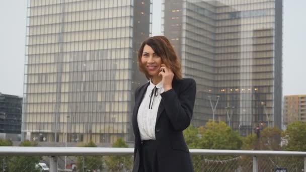 Slow motion journaliste femme en vêtements d'affaires parler sur smartphone aller au travail . — Video