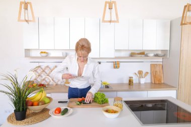 Mutfak kız smartphone elinde tutan ve sebze fotoğrafı çeker