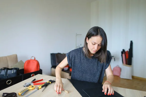 Muchacha mostrando cómo hacer bolso de cuero . — Foto de Stock