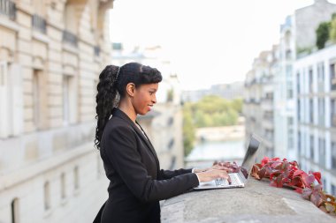 Mix kan emlakçı balkonda laptop ile çalışma.