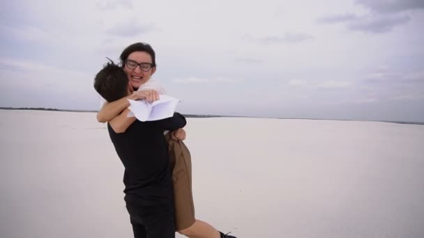 Slow motion recht studenten man en vrouw zich verheugen op het passeren van de examens dansen aan zee. — Stockvideo