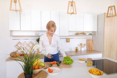 Güzel kız kesme tahtası üzerinde taze sebze salatası hazırlama