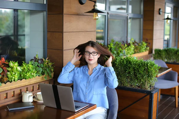 Estudiante charlando por ordenador portátil con amigos en la cafetería . — Foto de Stock