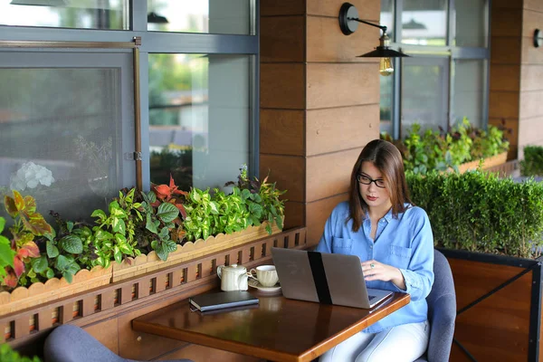 Redacción femenina escribiendo artículo por computadora portátil en el restaurante . — Foto de Stock