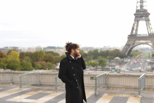 Brazilian male model calling photographer close to Eiffel Tower — Stock Photo, Image