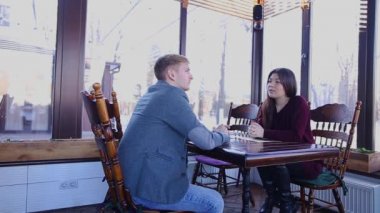 Genç kadını kocası kafeterya masada ile konuşma