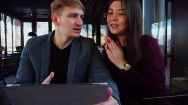 Kafede oturan ve yeni planlama çift gümüş dizüstü kullanarak ev