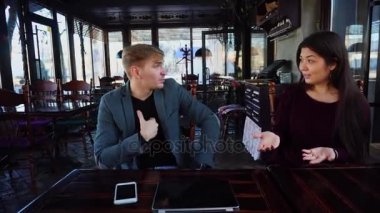 Çift, akıllı telefon ve dizüstü bilgisayar ile masanın kız erkek birlikte yeterli vakit için rahatsız