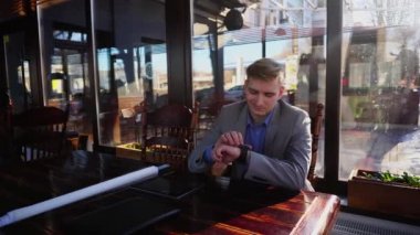 Café rulo proje, tablet ve belge durum tablo ile akıllı izle kullanarak iş adamı.