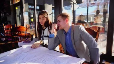 Genç tasarımcılar peyzaj proje ve belgeleri kafeterya masada çalışma.