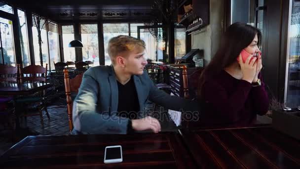 Freundin verursacht Freund Eifersucht, indem sie Freund mit Smartphone anruft, Kerl mit Smartwatch Handy abholt — Stockvideo