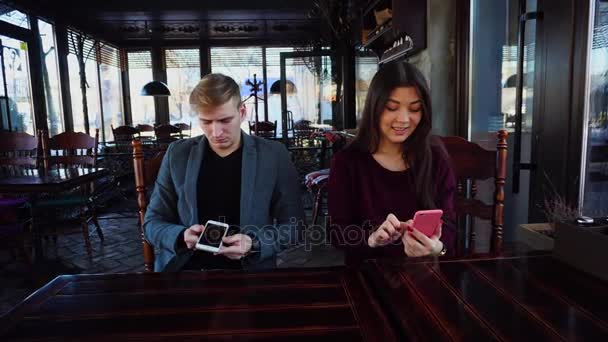 男朋友与 smartwatch 在手和女朋友测试智能手机 — 图库视频影像