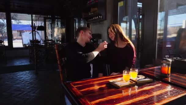 Веселий хлопчик годує дівчину в кафе . — стокове відео