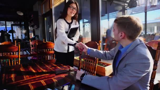 Sekretärin spricht mit Geschäftsmann im Café und zeigt Koffer mit Dokument. — Stockvideo