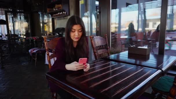Menina bonita conversando com smartphone em caso rosa . — Vídeo de Stock