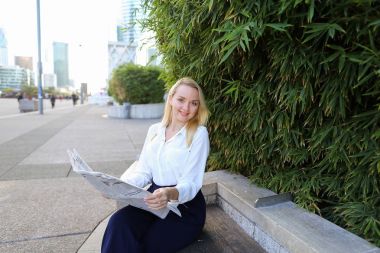 Açık havada yüz yakından ile gazete okuyan Bayan.