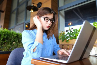 Smartphone ile konuşmak ve laptop ile café'de çalışan serbest meslek