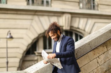 Açık gazete okuyan adam üzgün.